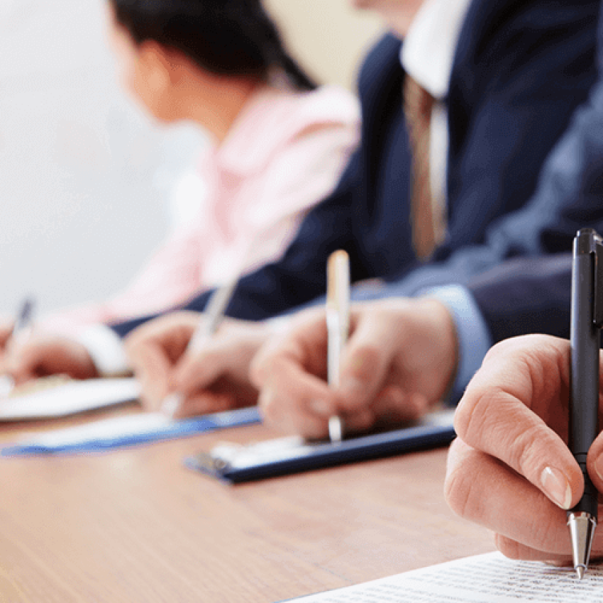 People in a conference room taking notes