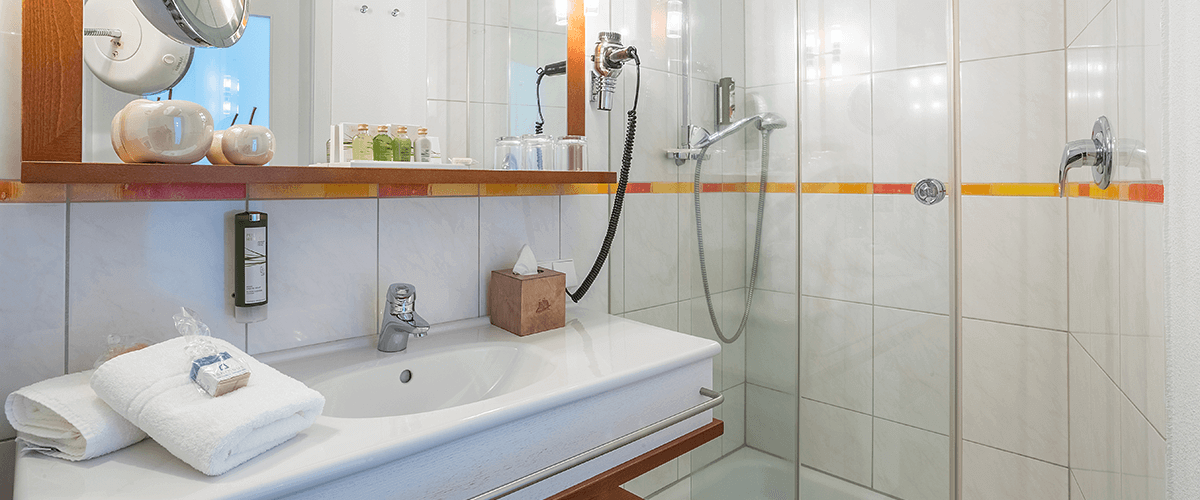 Blick ins Bad auf Waschbecken und Dusche