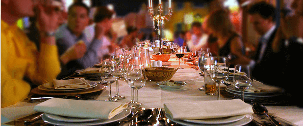 Feste und Events - Lange gedeckte Tafel mit Feiernden