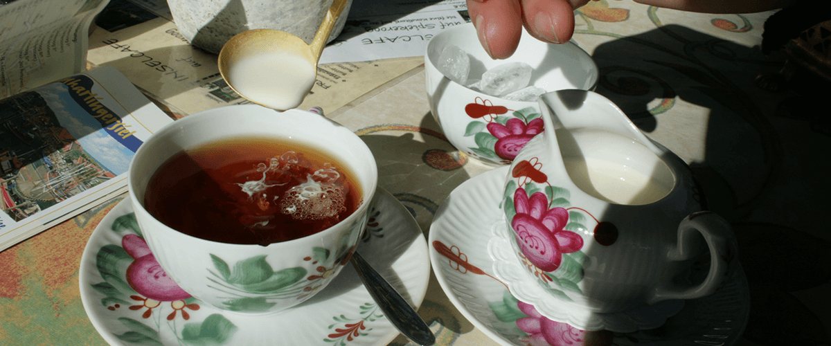 Zubereitung eines klassischen Ostfriesentees mit Sahne und Kluntje