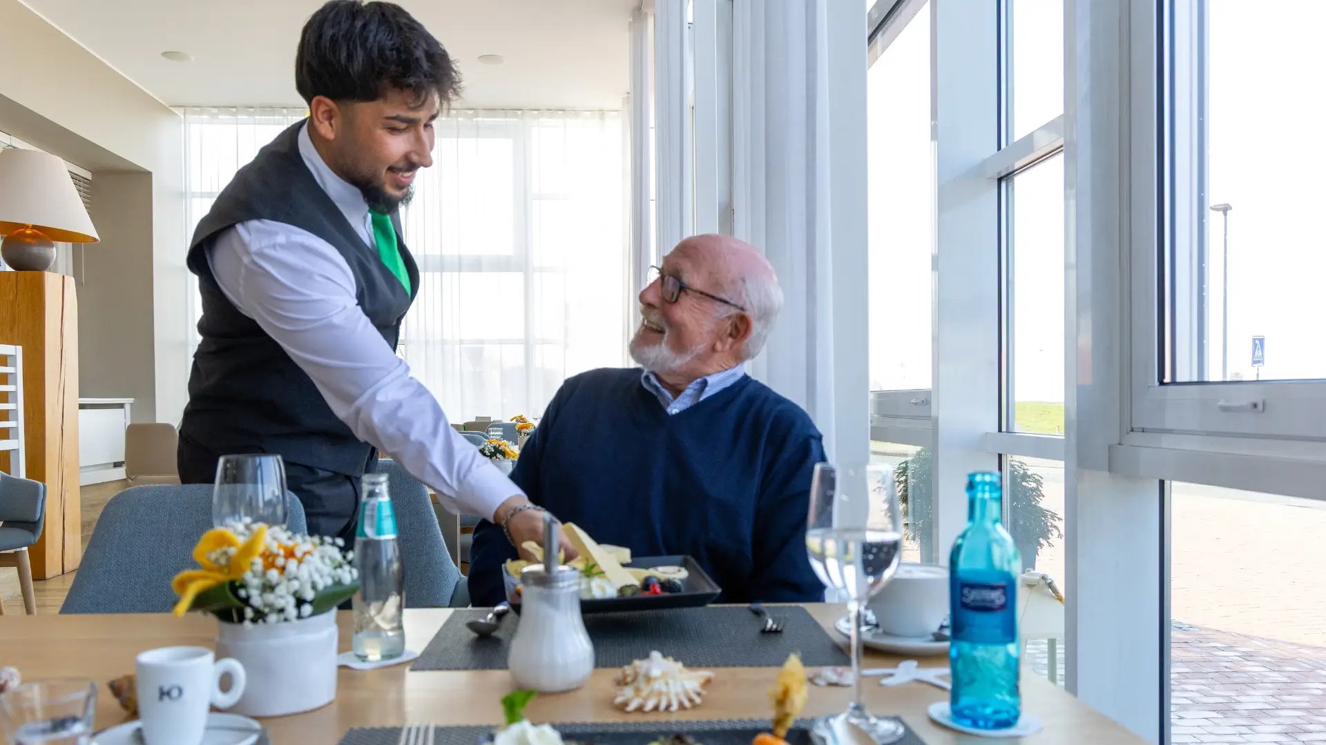 A man is served his meal by the waiter.