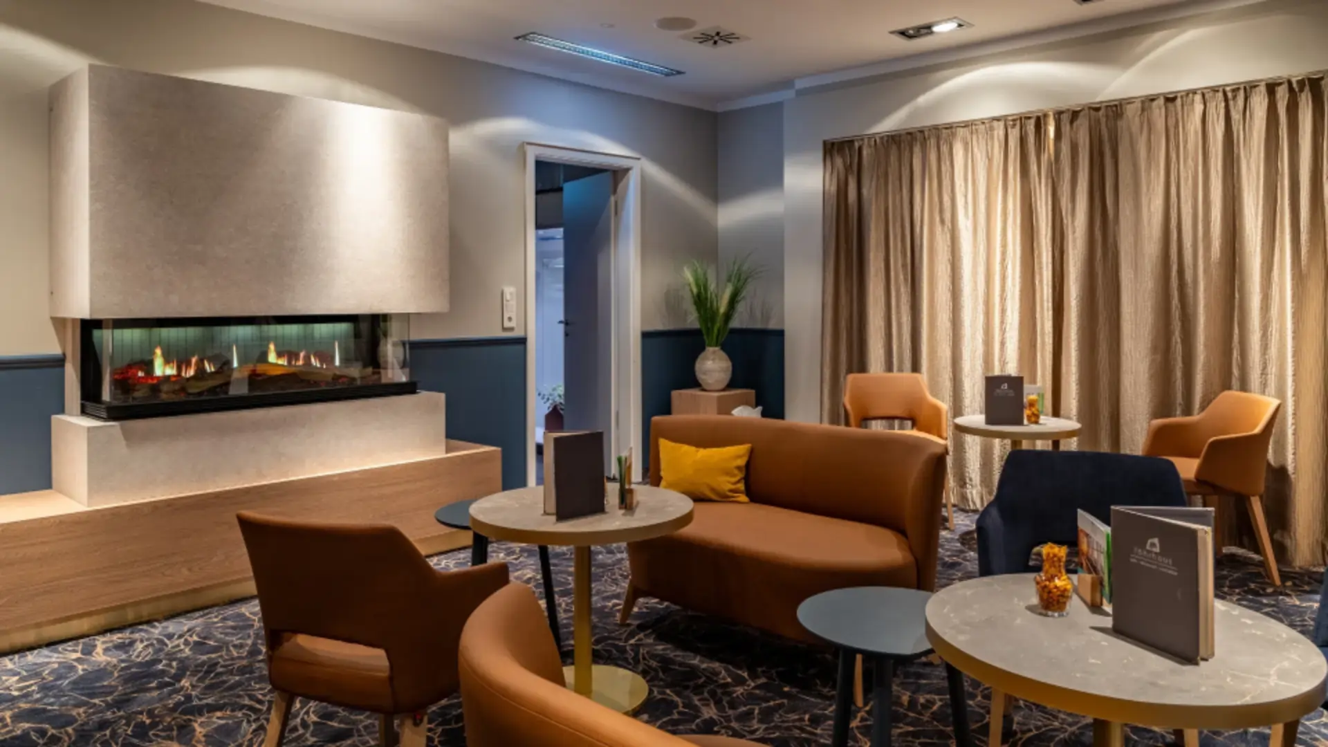 View of the Tenderbar's fireplace room, comfortable armchairs and benches in the perfect ambience