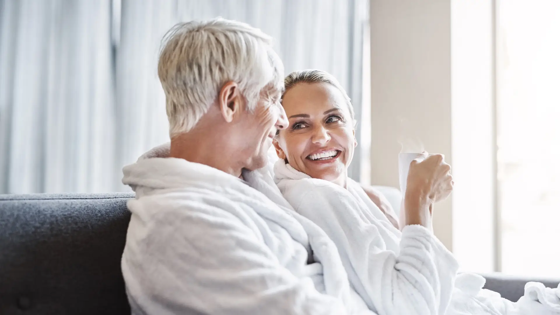 Couple relaxing in bathrobes with a hot cup of coffee or tea