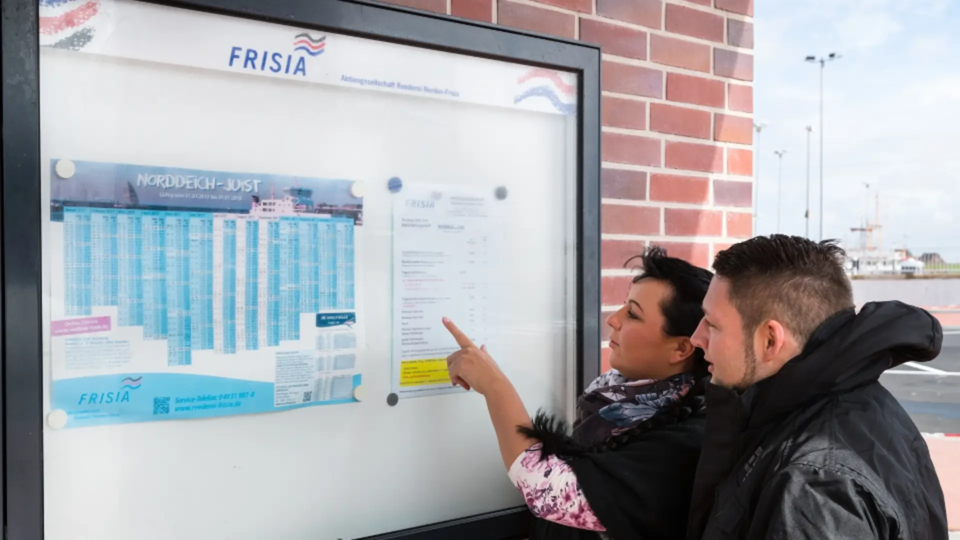 Couple checking the information board for the next ferry