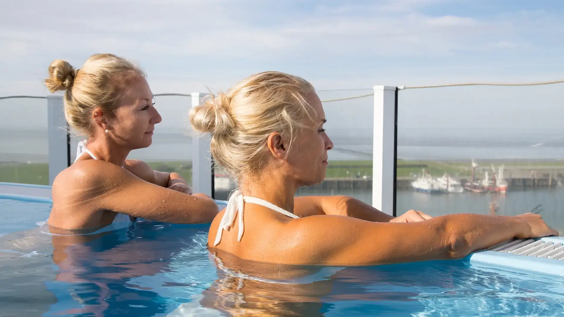 Two women enjoy the view from the infinity pool on the Wellness Upper Deck