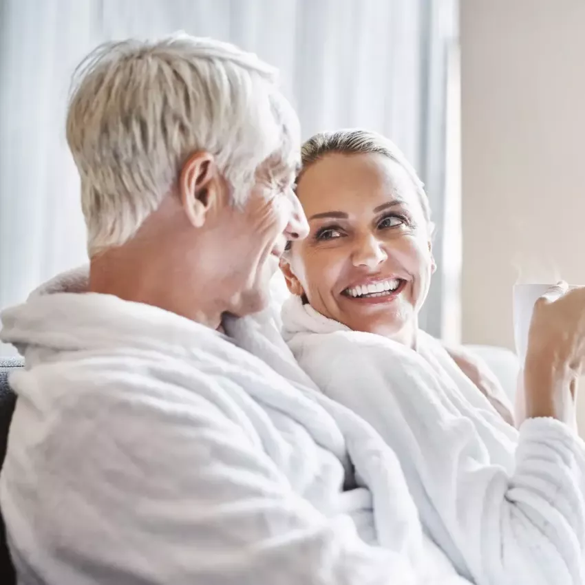 Pärchen entspannt im Bademantel bei einer heißen Tasse Kaffee oder Tee
